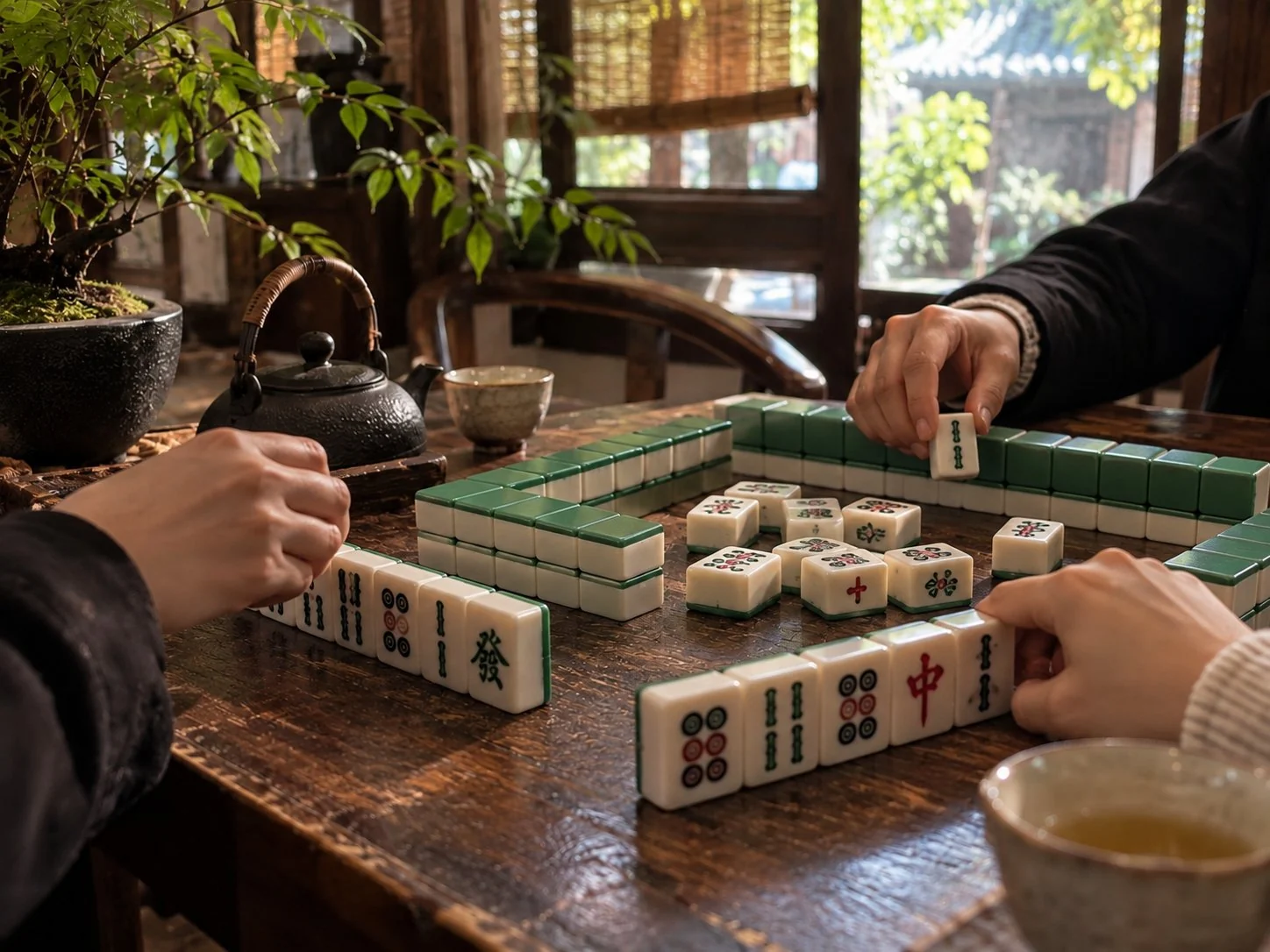 朋友在茶桌边摆放麻将牌